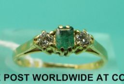 An 18ct gold ring set with a a square emerald and two diamonds (size K)