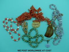 A small carved ivory oval panel, a jadeite beaded necklace, a jadeite brooch,