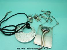 A white metal necklace and matching earrings set with hematite and another silver pendant