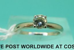 A white metal ring marked 14k set with a round brilliant cut diamond of approximately 0.