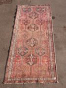 A wine ground Turkoman rug with geometric borders (L272xW125cm)