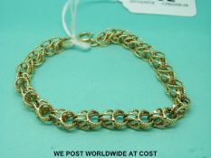 A yellow metal bracelet marked 14ct, made up of intertwined circular links (15.