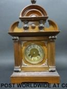 A mahogany and oak cased mantel clock with carved, fluted and turned decoration to the case,