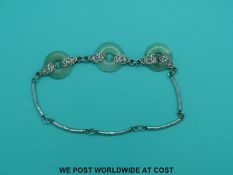 A silver necklace set with three jade bi-discs, 41cm long.
