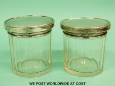 A pair of hallmarked silver topped cut glass dressing table bottles.