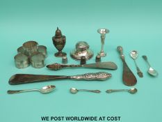 A hallmarked silver ink well, pepper, small silver vase, three silver handled shoe horns,