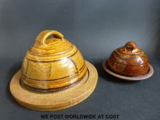 A Winchcombe Pottery cheese board with a dome and another smaller example