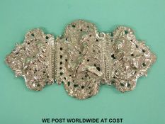 An Indian/Burmese white metal belt buckle decorated with a man riding a bird flanked by two further
