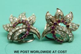 A pair of 18ct white gold earrings set with diamonds and rubies in a floral/foliate design
