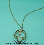 A yellow metal chain with a white and yellow metal pendant set with a moonstone and pearl