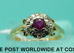 An 18ct gold ring set with a ruby surrounded by diamonds (size L)