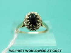 A 9ct gold ring set with a sapphire surrounded by diamonds (size O)