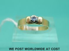 A yellow metal ring set with a diamond measuring approximately 0.