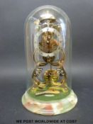 A brass skeleton clock under a dome (27cm tall)