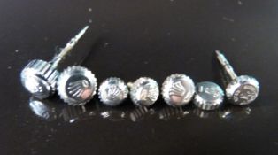 Seven Rolex stainless steel watch crowns,