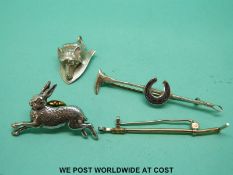 Four hunting related pins including a 9ct gold riding crop, silver riding crop,