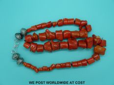 A very large coral style necklace of 48 natural graduated beads with embossed white metal fittings,