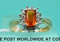 An 18ct gold ring set with a fire opal surrounded by diamonds (size L)