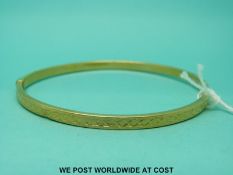 A 9ct gold bangle with cross decoration (3.