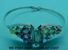 A silver bracelet set with multi-coloured sapphires including an oval cut pink,