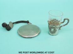 A hallmarked silver compact with engine turned decoration and a white metal mounted drinking glass,