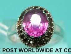 A silver ring set with an oval cut pink sapphire (size P)