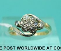 An 18ct gold ring set with diamonds in a flower cluster in a platinum setting (size M)