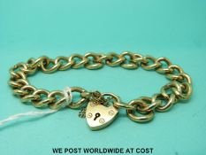 A 9ct gold curb link bracelet with a 9ct gold heart padlock clasp (33.