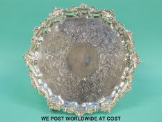 A George IV hallmarked silver salver with decorative rim raised on three scrolling feet,