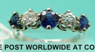 A white metal ring set with three sapphires and two diamonds (size M)