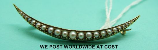 A Victorian yellow metal crescent brooch set with seed pearls