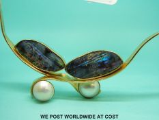A bespoke gold necklace set with two large sections of black opal and two mabe pearls