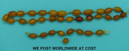 An amber necklace of 34 butterscotch coloured beads, all approx 13x9mm, 50cm long, 18g.