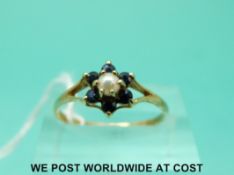 A 9ct gold ring set with a pearl surrounded by sapphires (size P)