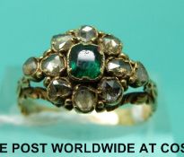 A yellow metal Victorian ring set with an emerald surrounded by rose cut diamonds (size M)