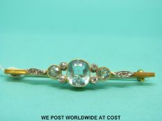 A yellow metal brooch set with aquamarines and diamonds.