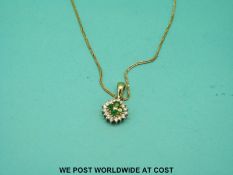 A yellow metal pendant marked 585 set with emeralds and diamonds on an 18ct gold chain