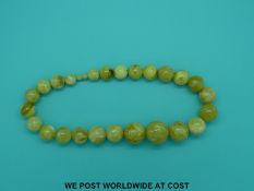 An amber necklace of 25 graduated spherical yellow coloured beads, the largest 30mm in diameter,