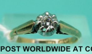 An 18ct gold ring set with a round cut diamond in a platinum setting (size L)