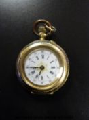 An 18ct gold ladies fob watch with Roman numerals and gilt detail to the white enamel face,