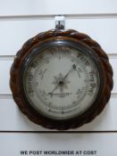 A Mappin & Webb carved oak cased circular aneroid barometer (16cm diameter dial)