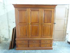 A hardwood three door wardrobe with six drawers below (W173 x D58 x H194cm)