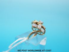 A 14ct gold ring set with six opals and two diamonds