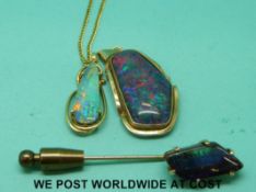 A yellow metal pendant set with a black opal cabochon on yellow metal chain,