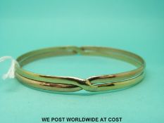 A 9ct bi coloured gold bangle (18g)