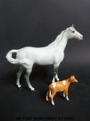 A Beswick swish tail grey horse together with a Beswick Guernsey calf