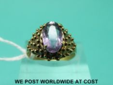 A yellow metal ring marked 333 set with an amethyst (size N)