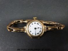 A 9ct gold ladies wristwatch and strap with enamel face