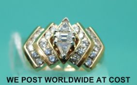 A yellow metal ring marked 14k set with an emerald cut diamond to the centre,