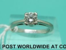 A platinum ring set with a round brilliant cut diamond of approximately 0.